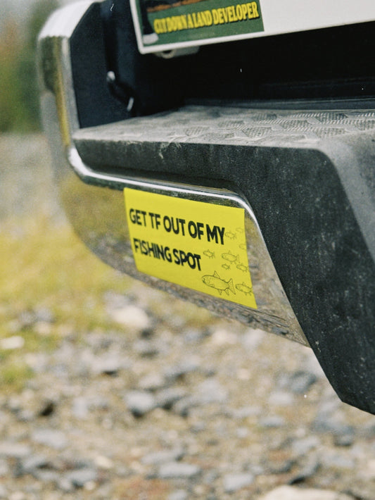 Bumper sticker on a vehicle's rear bumper with a natural background